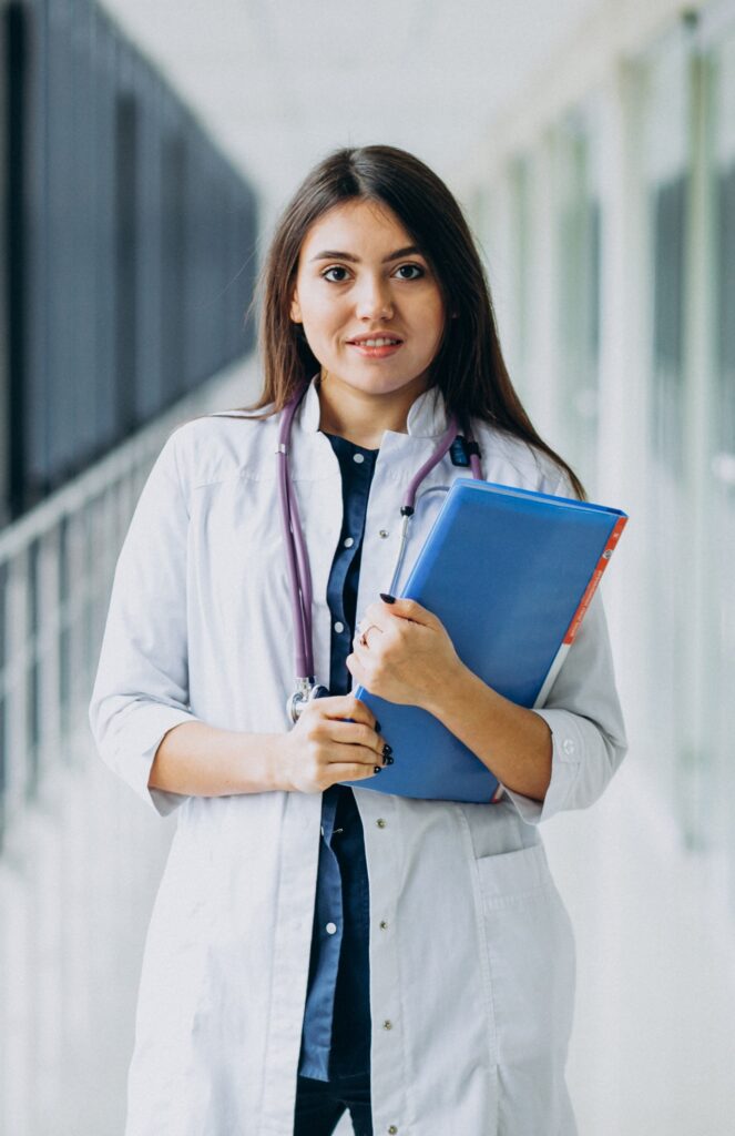 attractive female doctor standing with documents at the hospital attractive female doctor standing with documents at the hospital